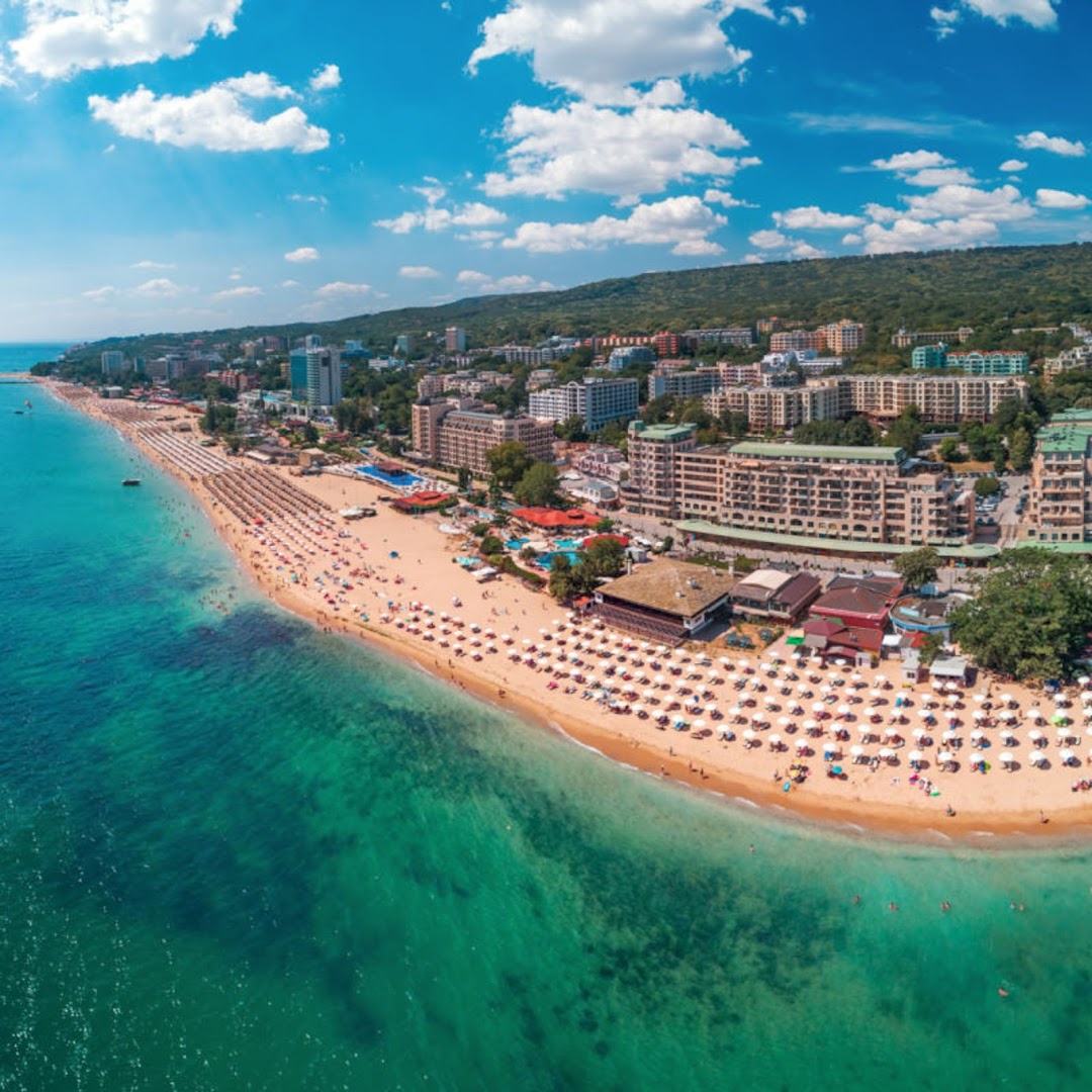 Aerofoto skats uz Zelta Smilšu kūrortu un Melia Grand Hermitage piekrasti — plaša smilšu pludmale ar saulessargiem un tirkīzzilu ūdeni