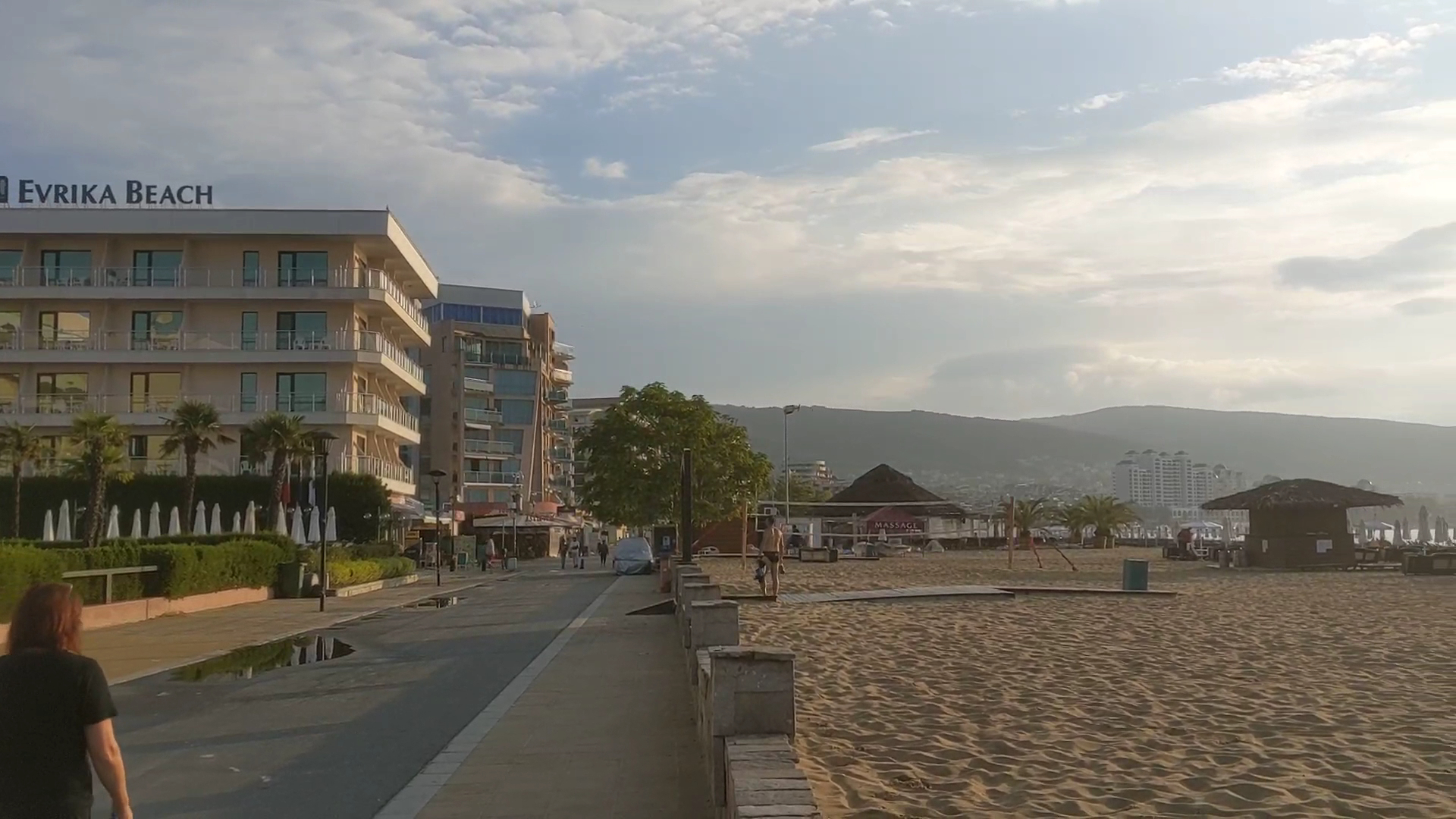 DIT Evrika Beach Club Hotel skats uz viesnīcas ēku un smilšu pludmali Saulainajā Krastā, Bulgārijā — promenāde un atpūtas zona pie jūras