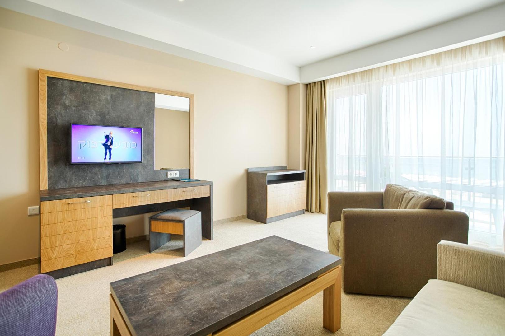 DIT Evrika Beach Club Hotel numura dzīvojamā zona ar dīvānu, galdiņu un TV Saulainajā krastā, Bulgārijā