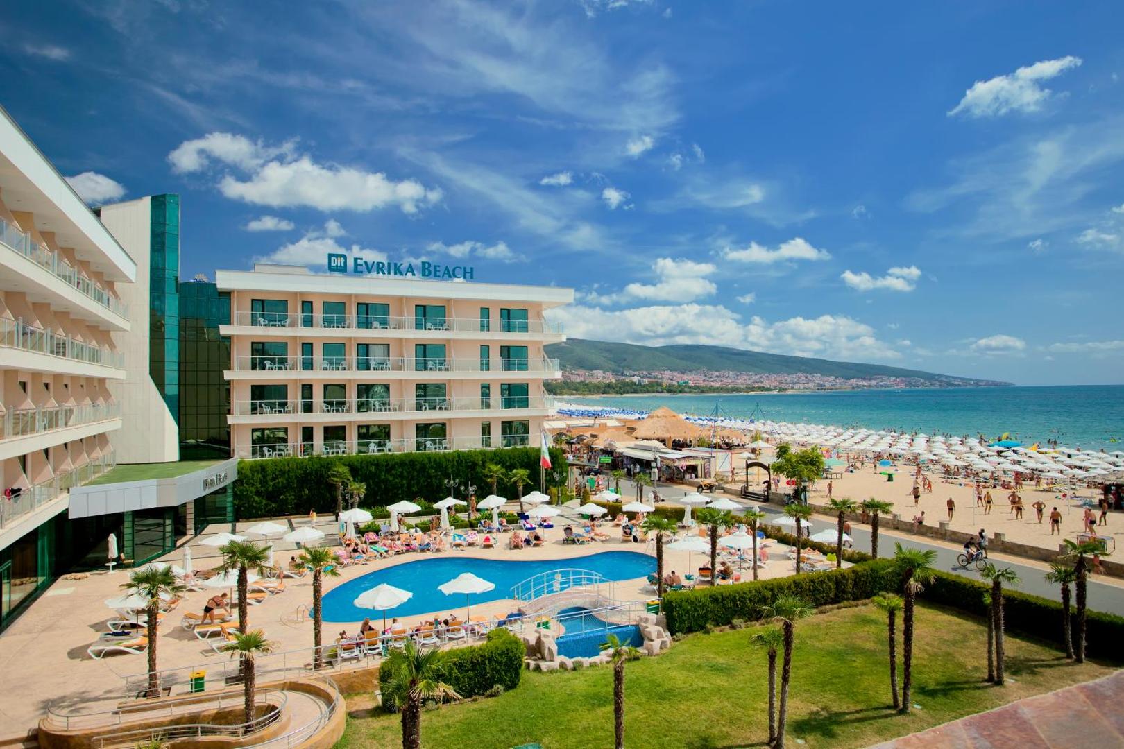 DIT Evrika Beach Club Hotel skats no augšas uz baseinu, viesnīcas korpusu un Saulainā Krasta pludmali Bulgārijā