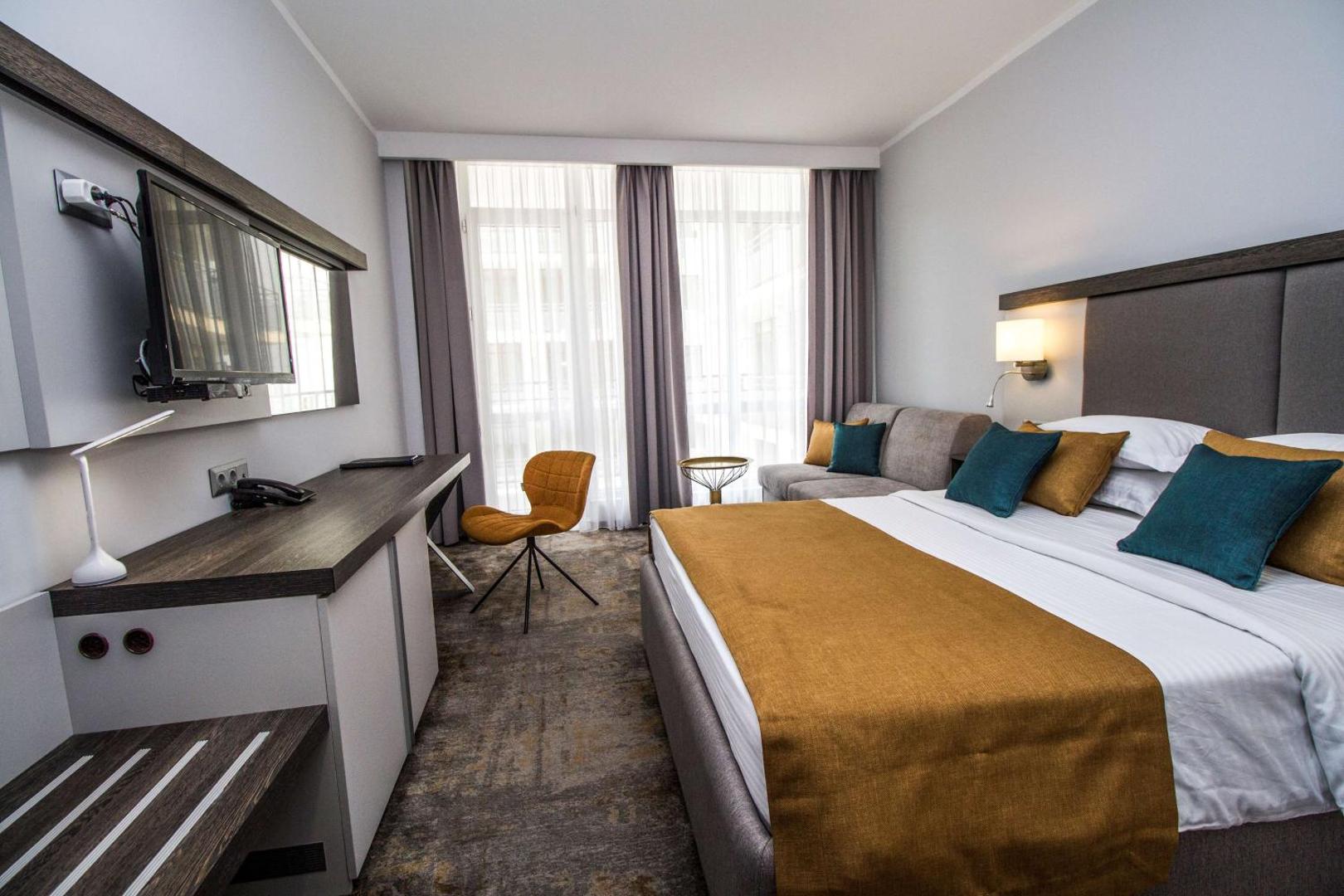 Best Western Plus Premium Inn moderns numurs ar divguļamo gultu, dīvānu, darba galdu un lieliem logiem Saulainajā krastā