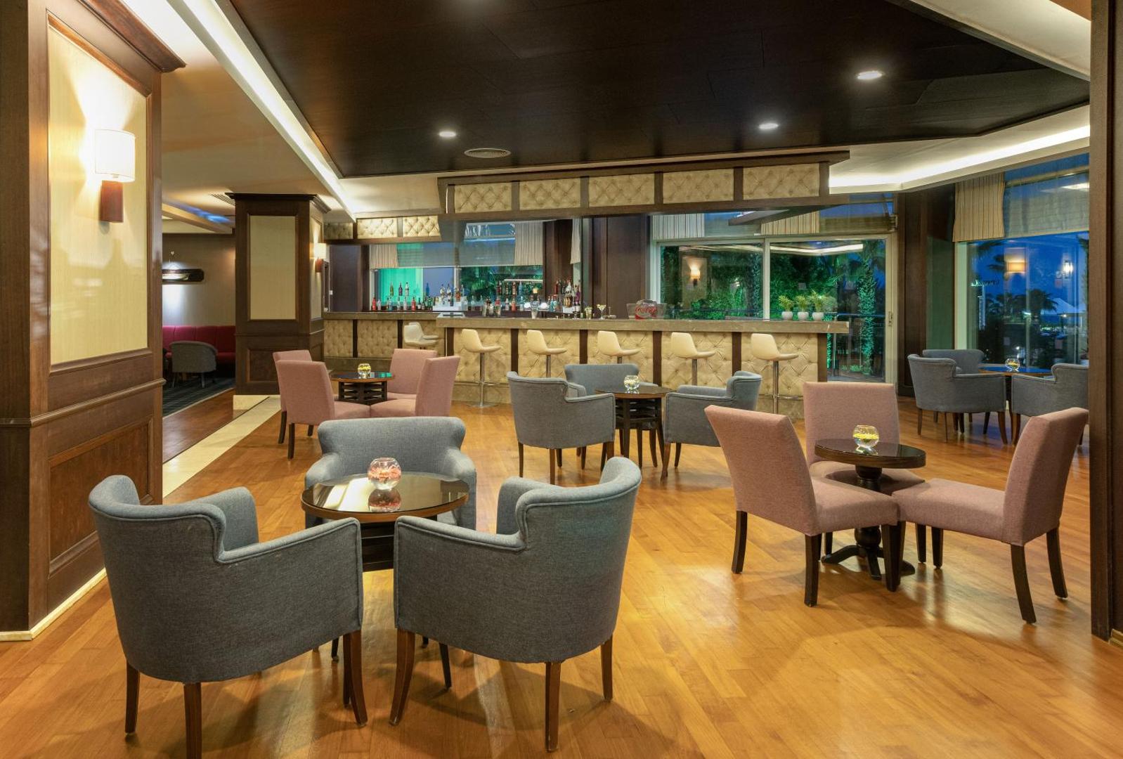 Kaya Belek lobby bārs ar moderniem krēsliem, koka apdari un plašu dzērienu izvēli viesnīcas galvenajā ēkā.