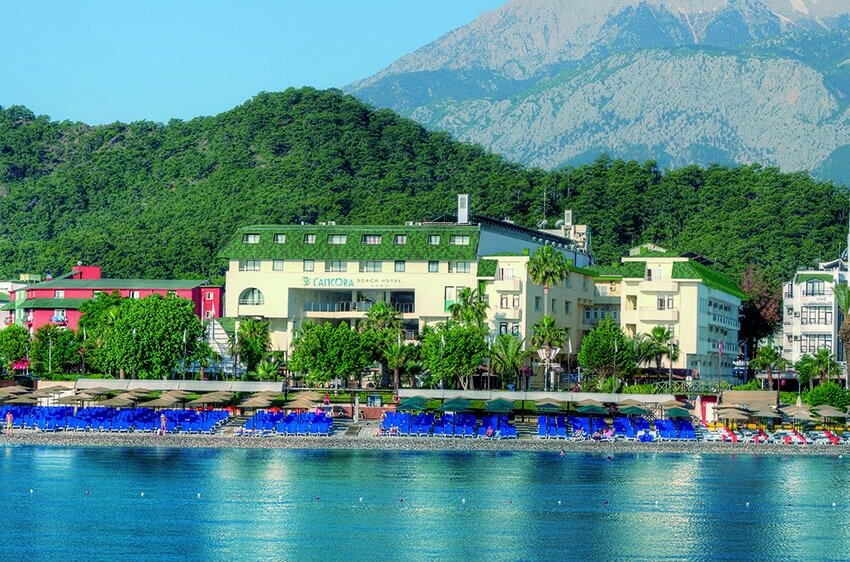 L'ancora Beach Hotel ēka un pludmales zona Kemerā — skats uz Vidusjūras piekrasti, oļu pludmali un zaļajiem kalniem