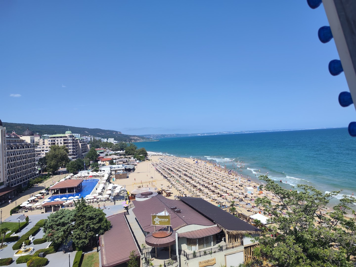 Panorāmas skats uz Golden Line viesnīcas apkārtni, plašo smilšu pludmali ar saulessargiem un zilo jūru Zelta smiltīs