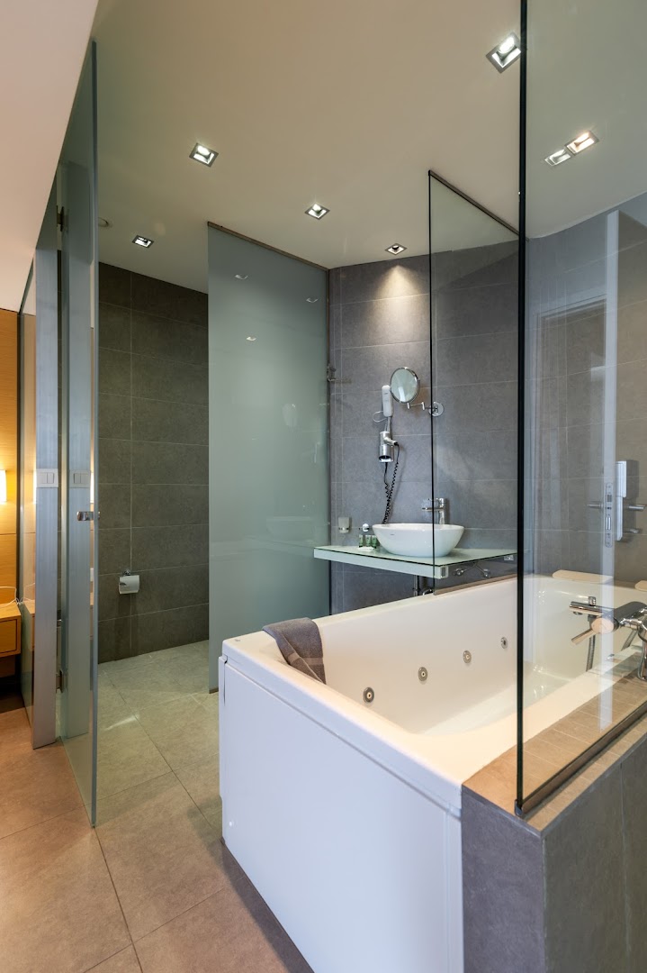 Atlantis Boutique City Hotel moderns numurs ar lielu vannu, stikla starpsienām un elegantu apgaismojumu Rodas pilsētā