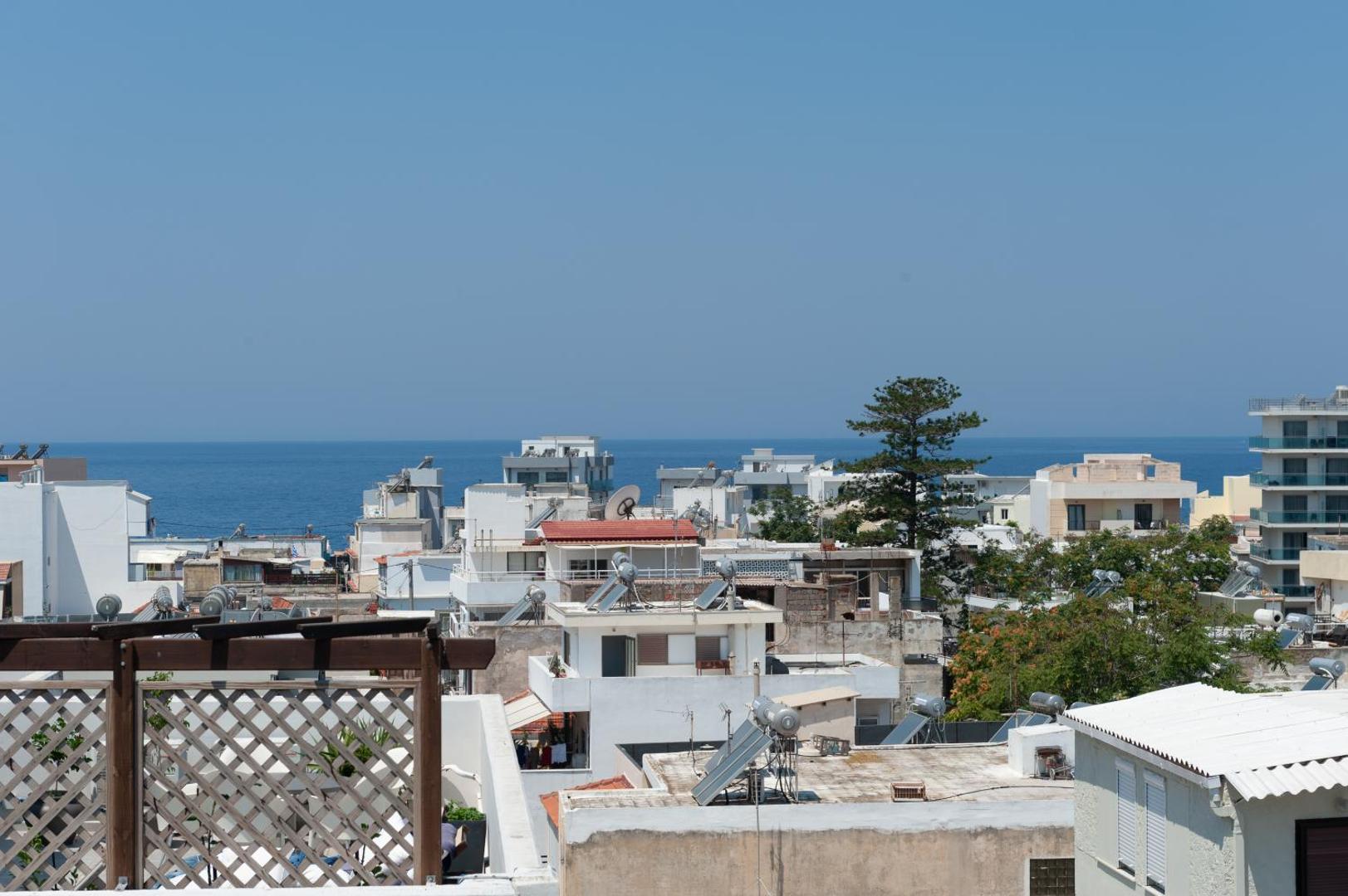 Atlantis Boutique City Hotel skats no jumta terases uz Rodas pilsētas apbūvi un zilo Vidusjūru horizontā saulainā dienā