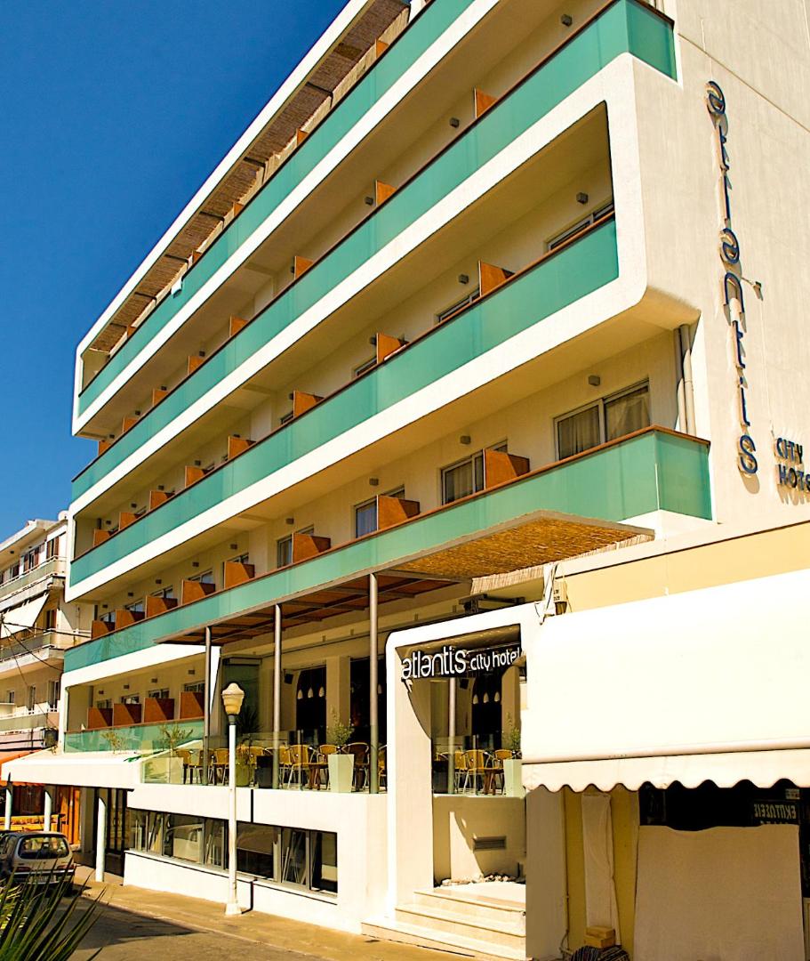 Atlantis Boutique City Hotel ēkas skats no apakšas dienas laikā — balta fasāde ar tirkīza krāsas balkonu margām Rodā.