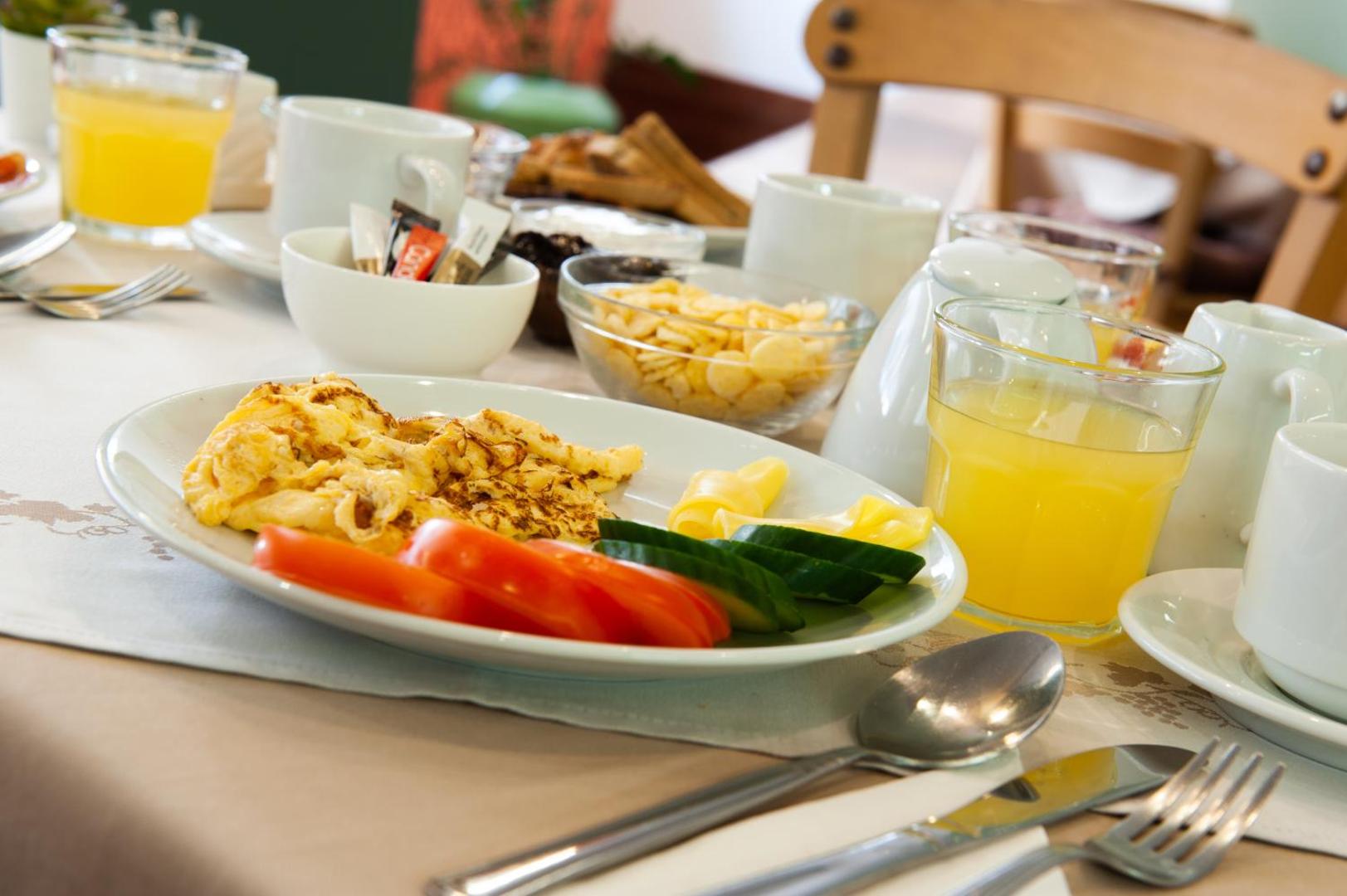Atlantis Boutique City Hotel brokastu piedāvājums Rodas pilsētā — šķīvis ar omleti, svaigiem tomātiem, gurķiem un apelsīnu sulu