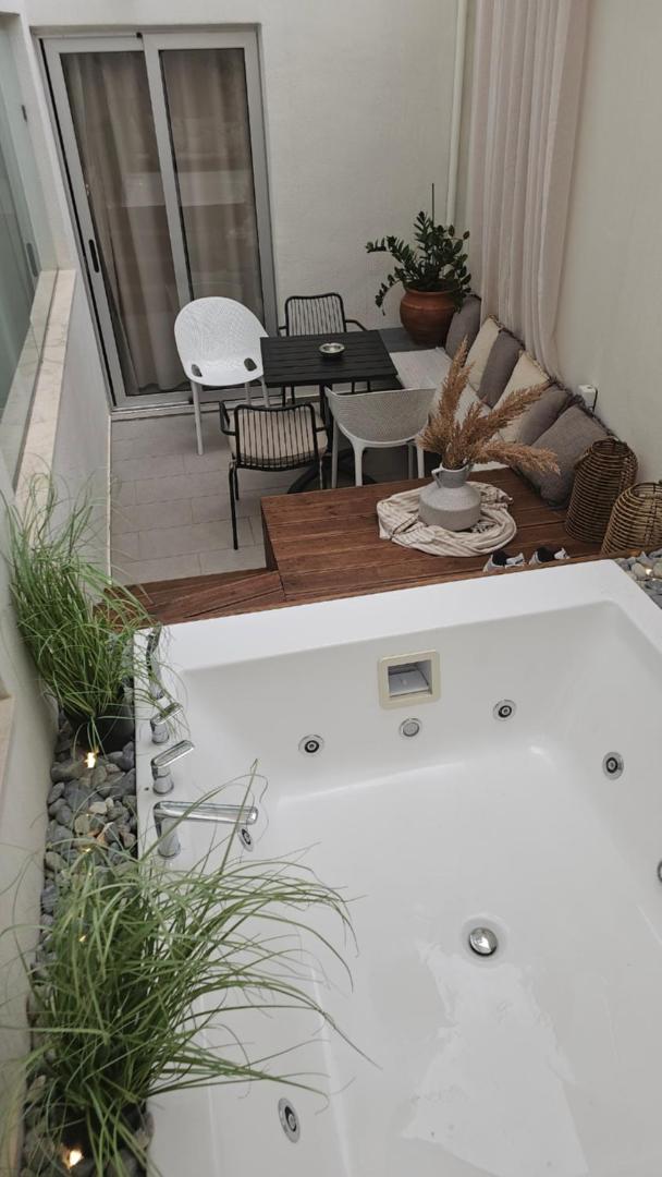 Privāta terase ar džakuzi, atpūtas krēsliem un dekoratīviem augiem Atlantis Boutique City Hotel numurā Rodā.