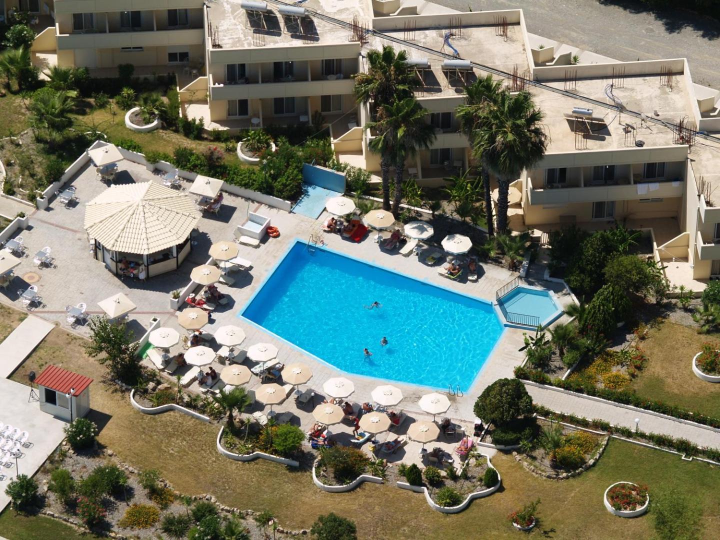 Olive Garden Hotel Rodā centrālais baseins ar bērnu zonu, saulessargiem un bāru — skats no augšas uz atpūtas zonu