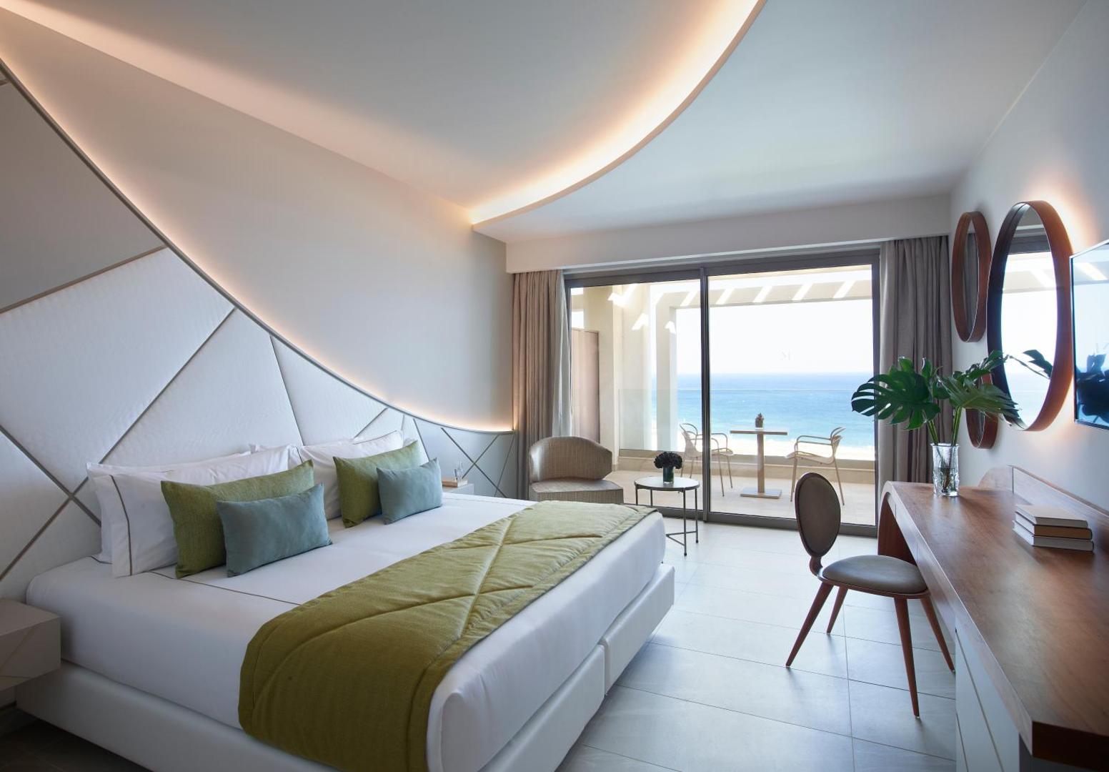 Mayia Exclusive Resort & SPA moderns numurs ar skatu uz jūru Rodā — gaišs interjers, liela gulta un privāts balkons