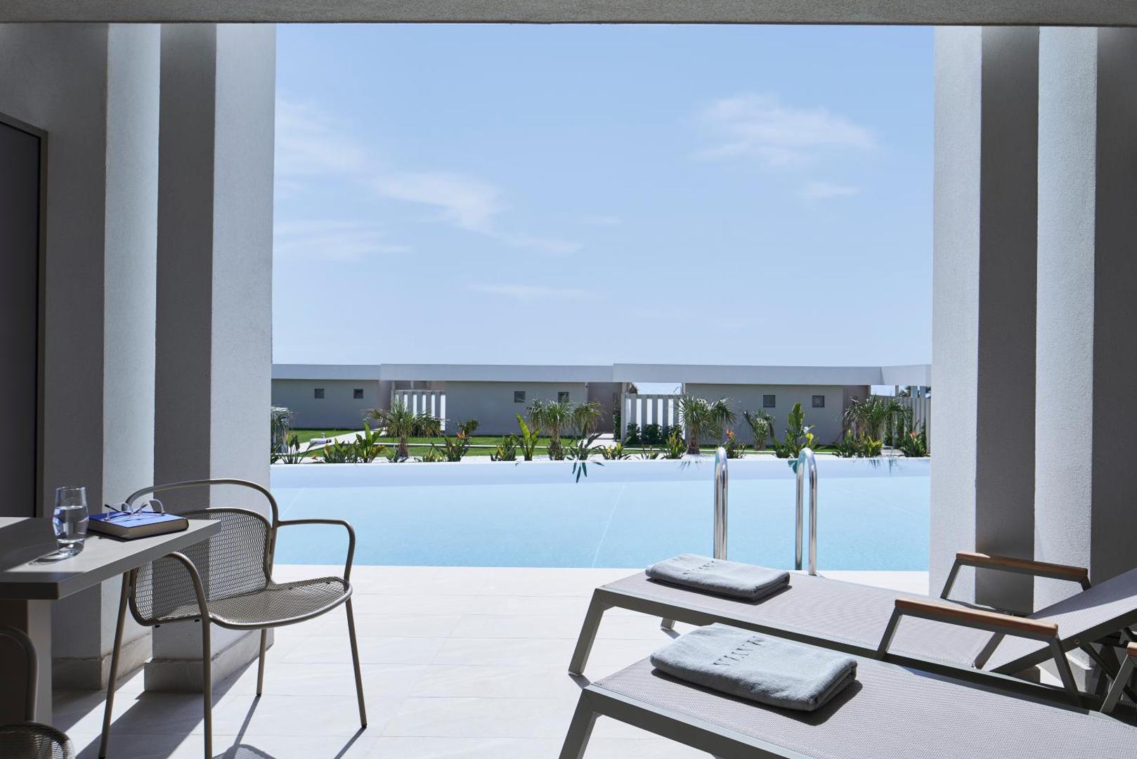 Mayia Exclusive Resort & SPA privātā terase ar sauļošanās krēsliem un skatu uz koplietošanas baseinu Rodas kūrortā