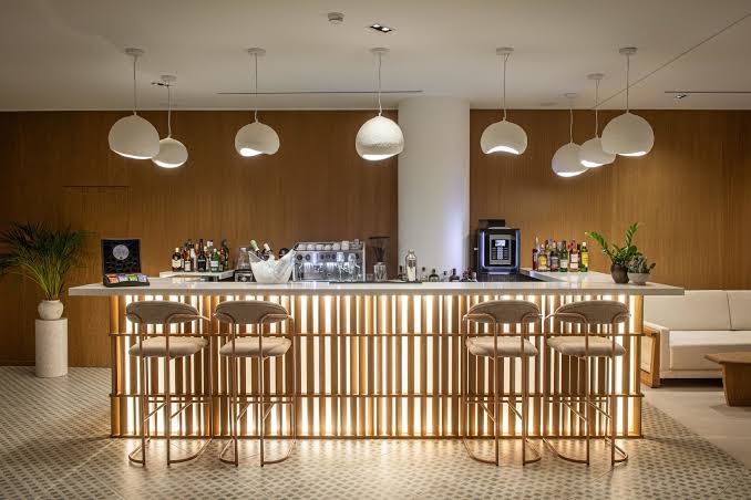 Aelius Hotel and Spa modernais lobby bārs ar izgaismotu leti, stilīgiem bāra krēsliem un dizaina lampām Krētas kūrortā