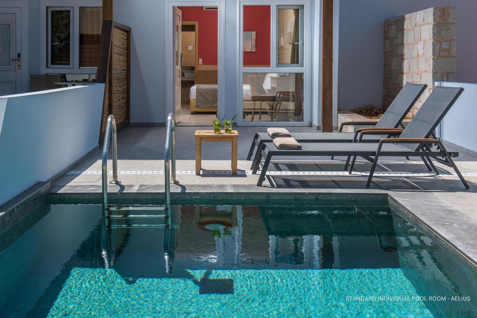 Aelius Hotel and Spa numurs ar tiešu piekļuvi baseinam, privāta terase ar sauļošanās krēsliem un kokteiļiem Krētā.