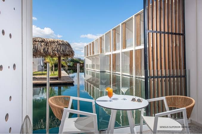 Aelius Hotel and Spa swim-up numura terase ar galdiņu un skatu uz koplietošanas baseinu un bungalo stila saulessargiem