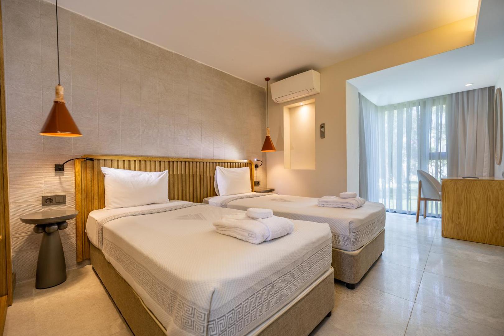 Gaišs Von Resort Golden Beach guļamistabas numurs ar divām gultām, modernu apgaismojumu un lielu logu