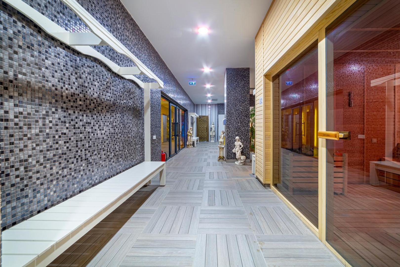 Lonicera Premium spa zonas gaitenis ar ieeju saunā, mozaīkas flīžu sienām un dekoratīvām statujām Alanjas kūrortā