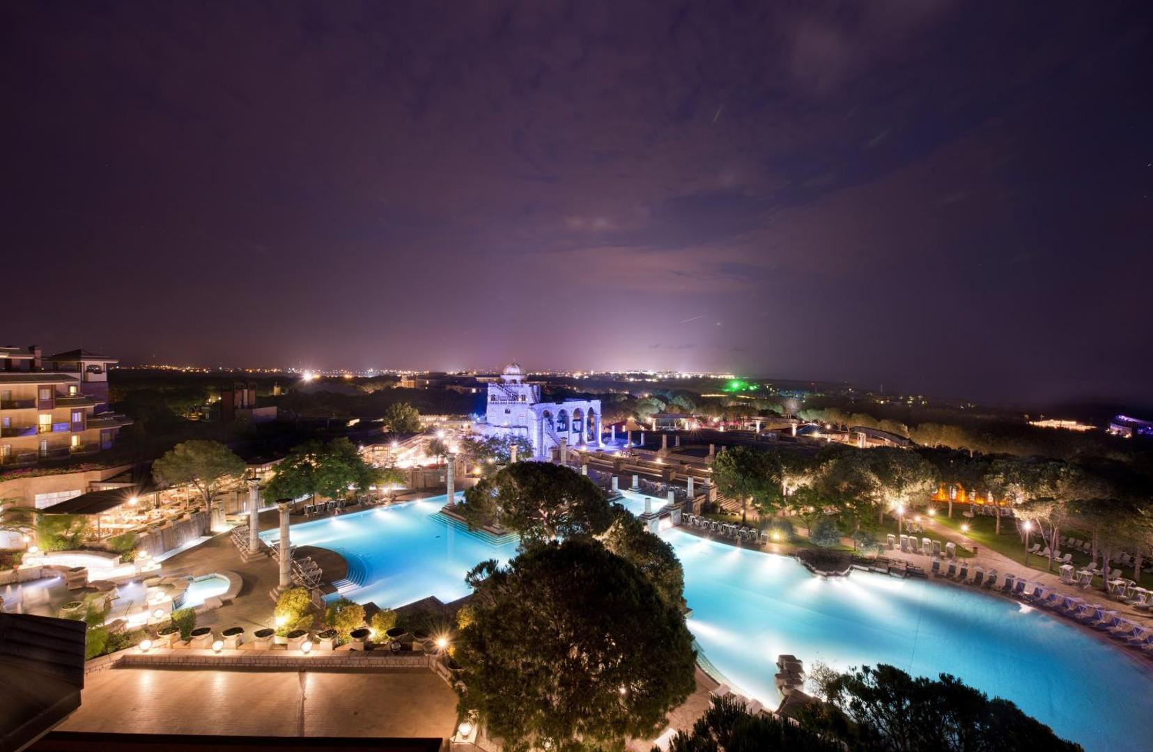 Panorāmas skats uz Xanadu Resort Hotel izgaismoto teritoriju, baseiniem un amfiteātri nakts laikā Belekā