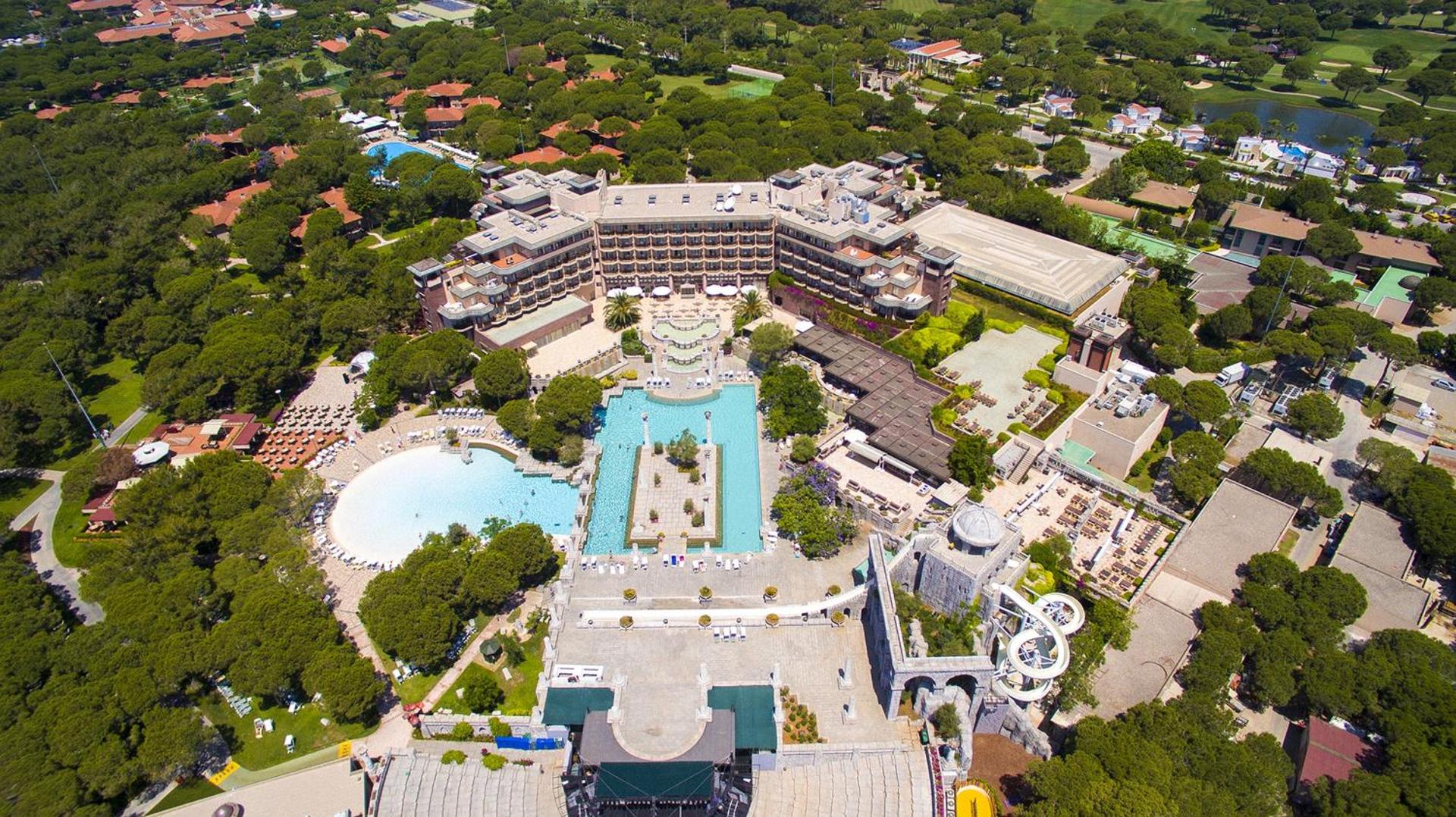 Xanadu Resort Hotel Belekā no putna lidojuma — galvenā ēka, plašs baseinu komplekss un antīka stila arhitektūras elementi priežu meža ielokā