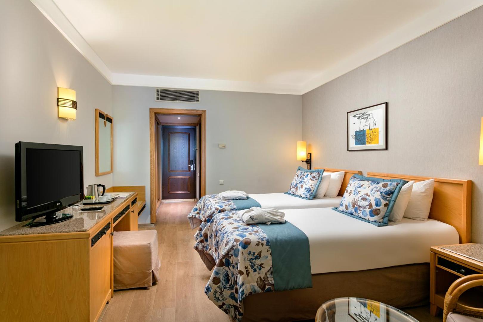 Xanadu Resort Hotel numurs ar divām atsevišķām gultām, gaišām sienām, rakstāmgaldu un gaisa kondicionieri Belekas kūrortā Turcijā