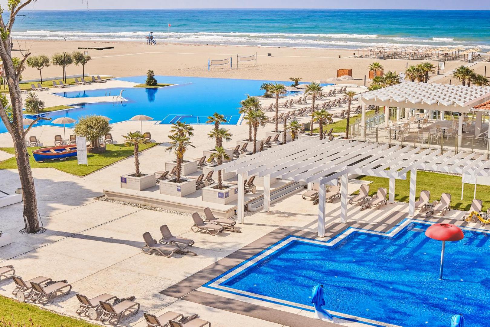 Azul Beach Resort Montenegro bērnu baseins ar sēnītes formas strūklaku un pieaugušo baseins blakus pludmalei Ulciņas reģionā