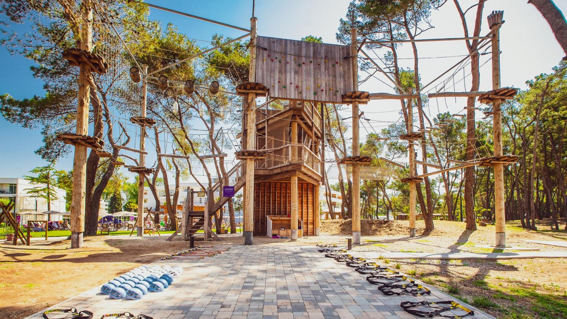 Azul Beach Resort Montenegro piedzīvojumu parks ar virvju trasēm un kāpšanas sienu priežu mežā pie pašas pludmales.