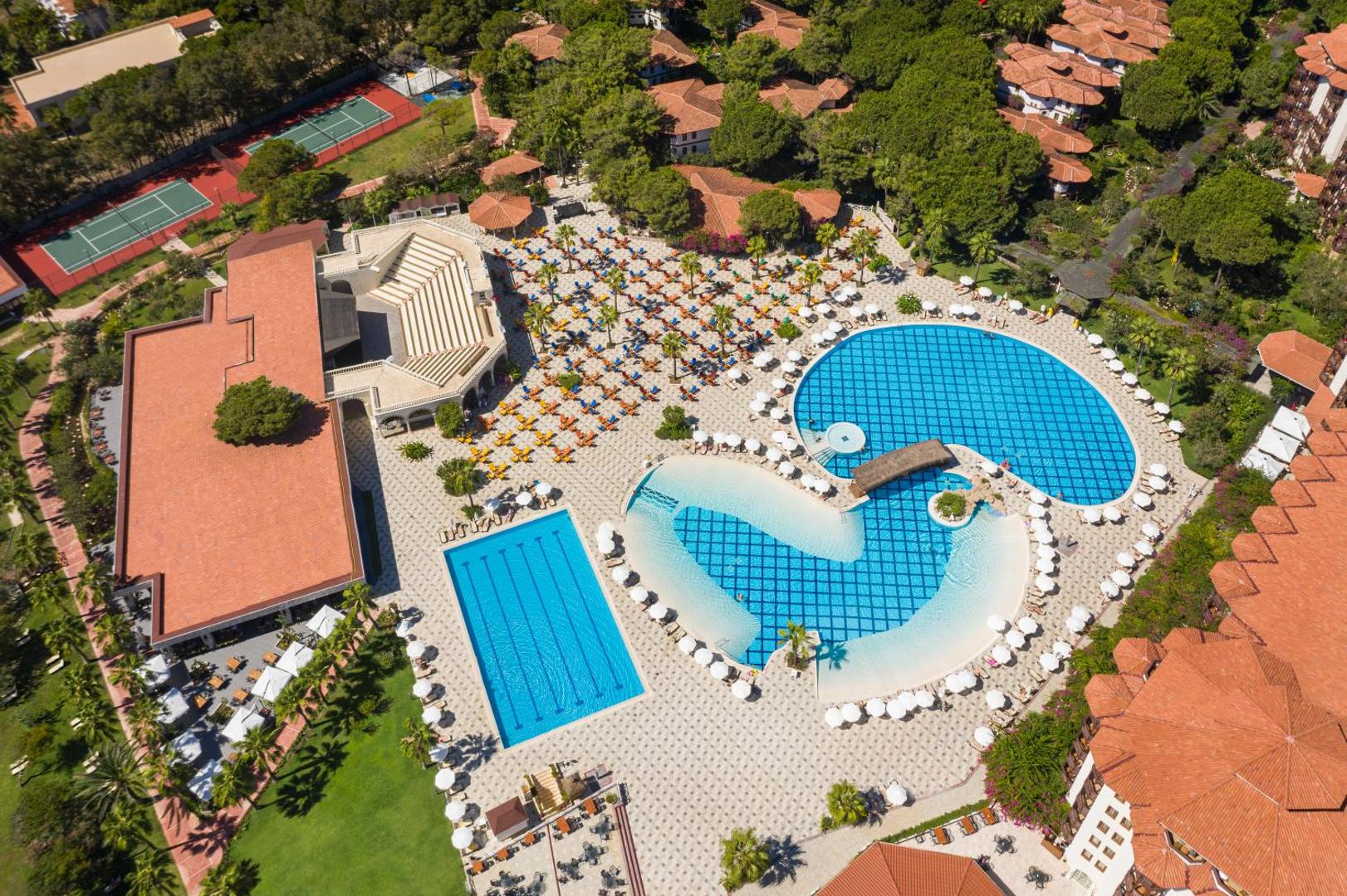 Selectum Family Resort Belek teritorijas skats no putna lidojuma ar baseiniem, tenisa kortiem un amfiteātri Belekā.