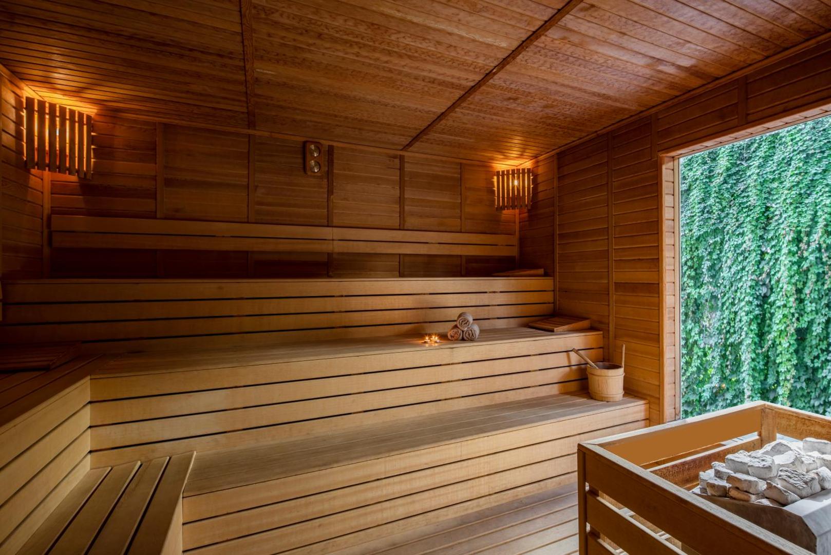 Papillon Ayscha spa centra koka sauna ar plašu logu, no kura paveras skats uz zaļojošu augu sienu