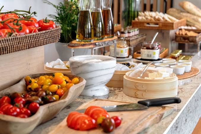 The Chedi Lustica Bay brokastu bufete ar svaigiem dārzeņiem, olīveļļu un vietējiem produktiem Melnkalnē — bagātīga veselīgu produktu izvēle