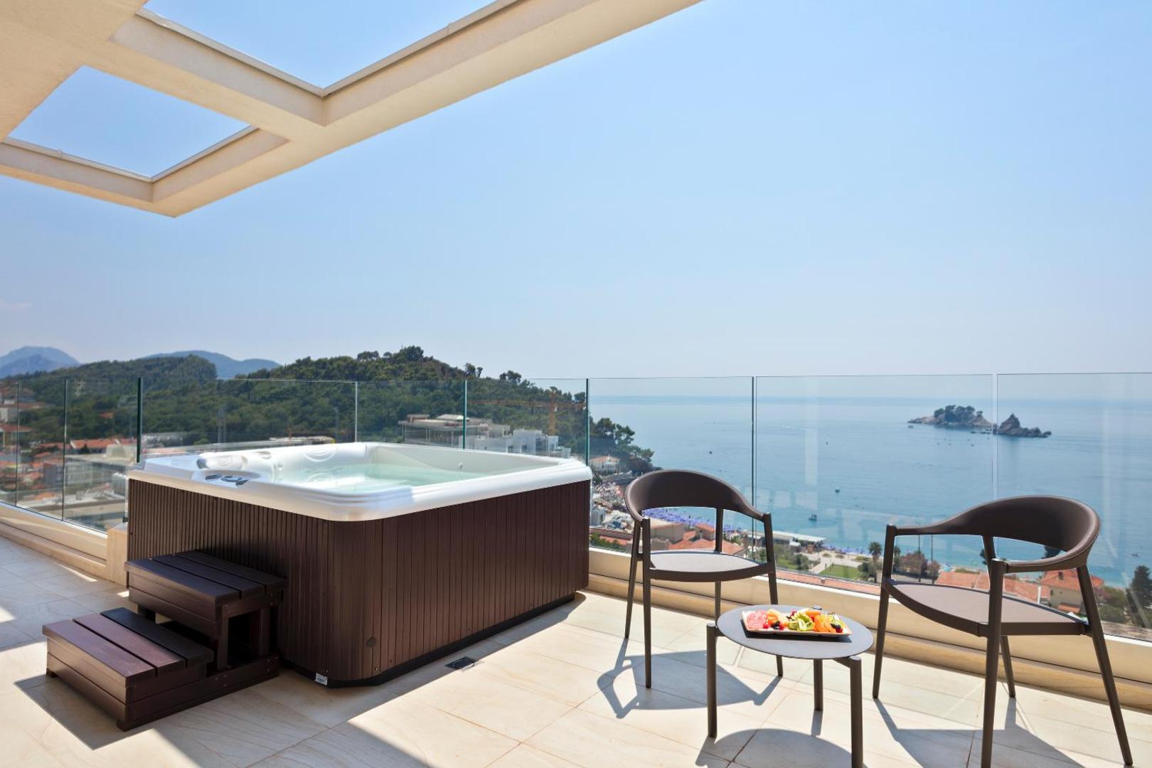 Hotel Ami Budva Petrovac terase ar privātu džakuzi, atpūtas krēsliem un iespaidīgu skatu uz jūru un piekrastes salām.