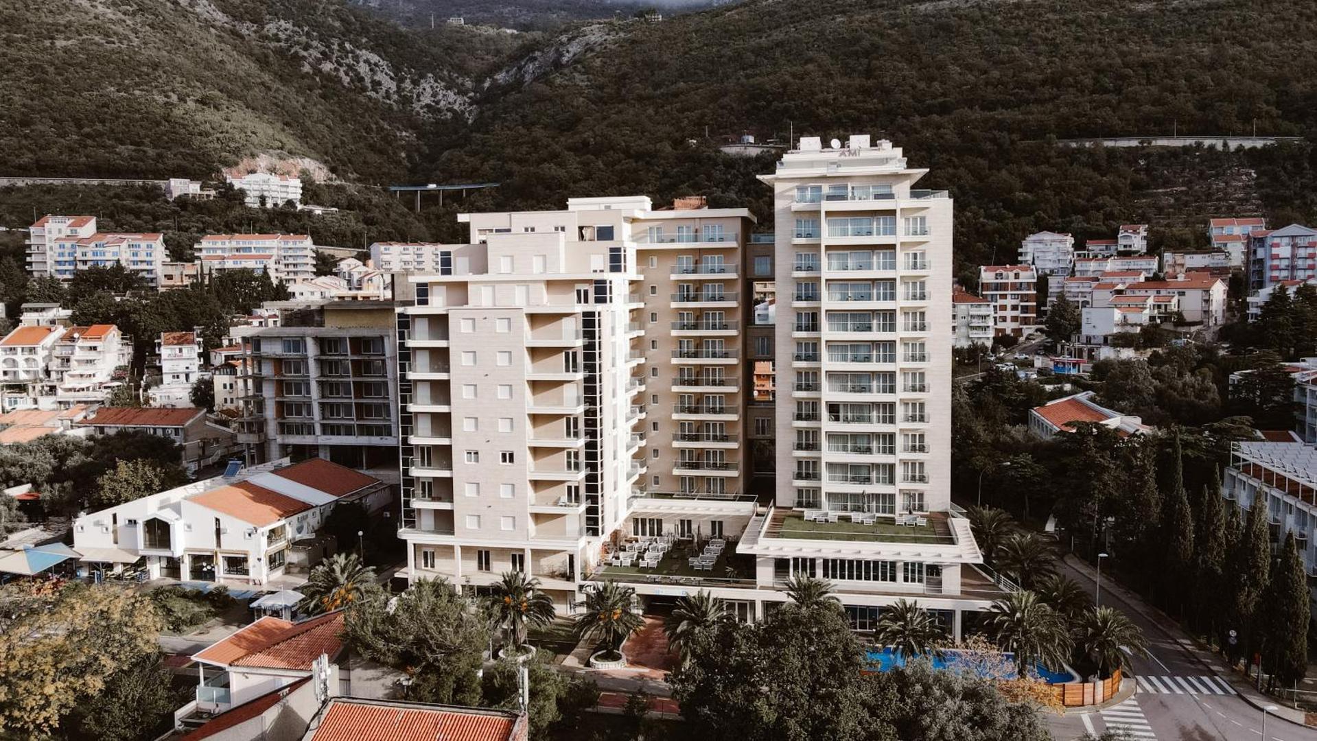 Aerofoto skats uz Hotel Ami Budva Petrovac kompleksu Petrovacā, Melnkalnē, apkārt esošajiem kalniem un pilsētas apbūvi