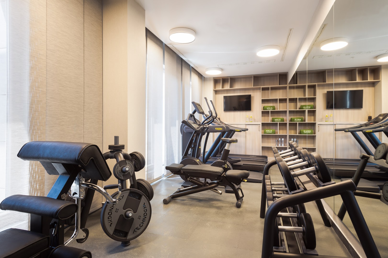 Hotel Ami Budva Petrovac fitnesa zāle ar Technogym spēka trenažieriem, hantelēm un lieliem spoguļiem Petrovacā