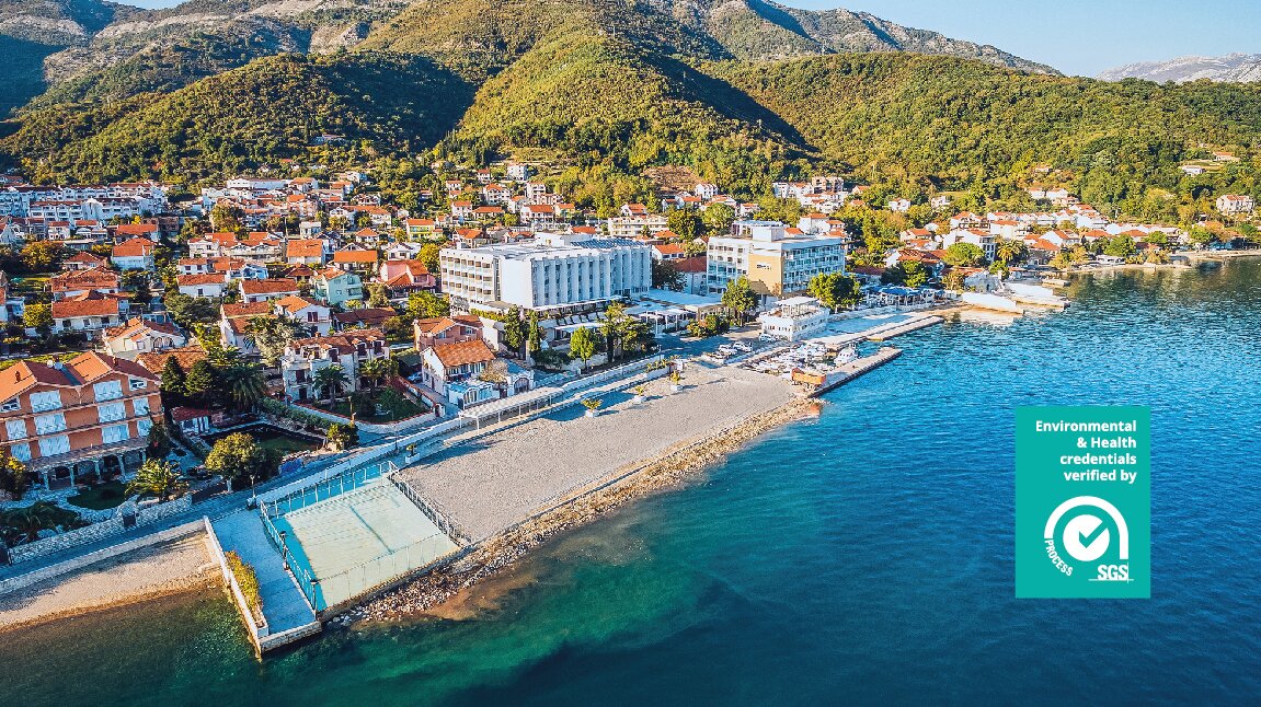 Pilsētas pludmale ar viesnīcām un kalnu fona, kas piedāvā skaistu ainavu un atpūtas iespējas. Zilais ūdens un saulainā atmosfēra veicina patīkamu atpūtu. panoramic view with beach and pools