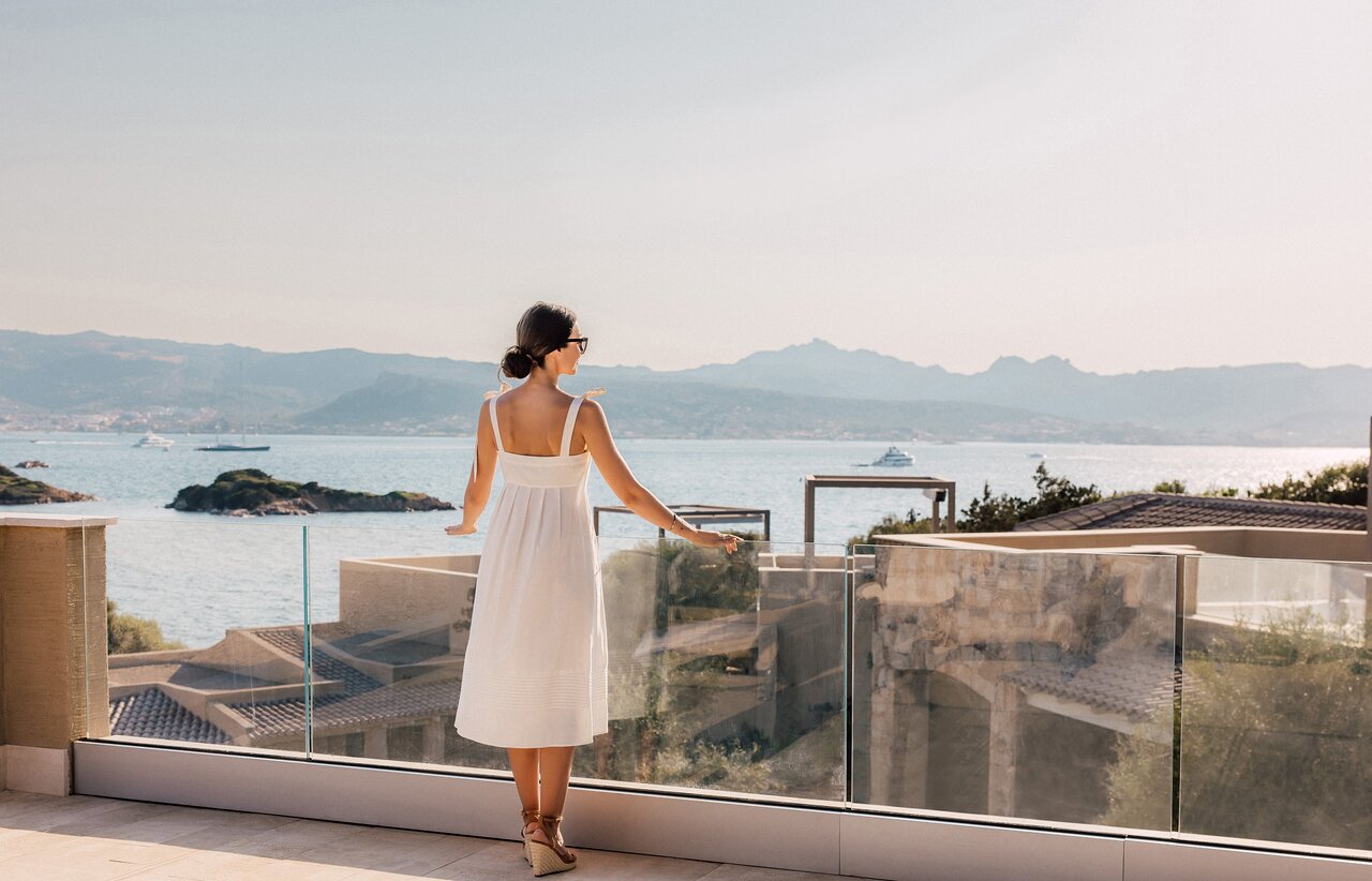 Sieviete uz balkona ar skatu uz jūru 7 Pines Resort Sardinia