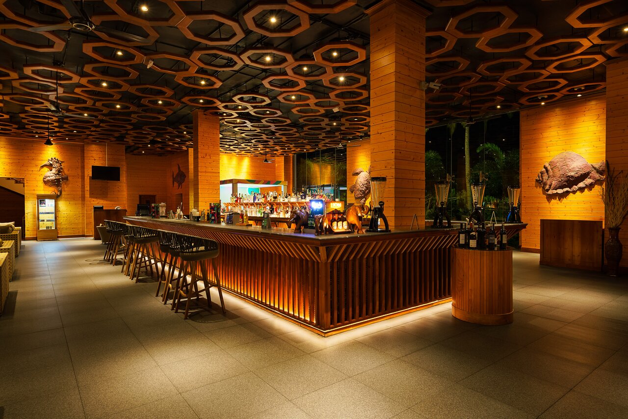 Araliya Beach Resort & Spa bārs ar elegantu koka dizainu.