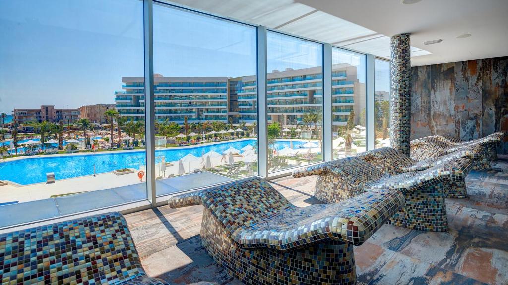 Mūsdienīgs spa ar panorāmas logiem, kas paver skatu uz baseinu un atpūtas zonu ar sauļošanās krēsliem. Interjers ir veidots ar mozaīkas elementiem, radot relaksējošu atmosfēru.