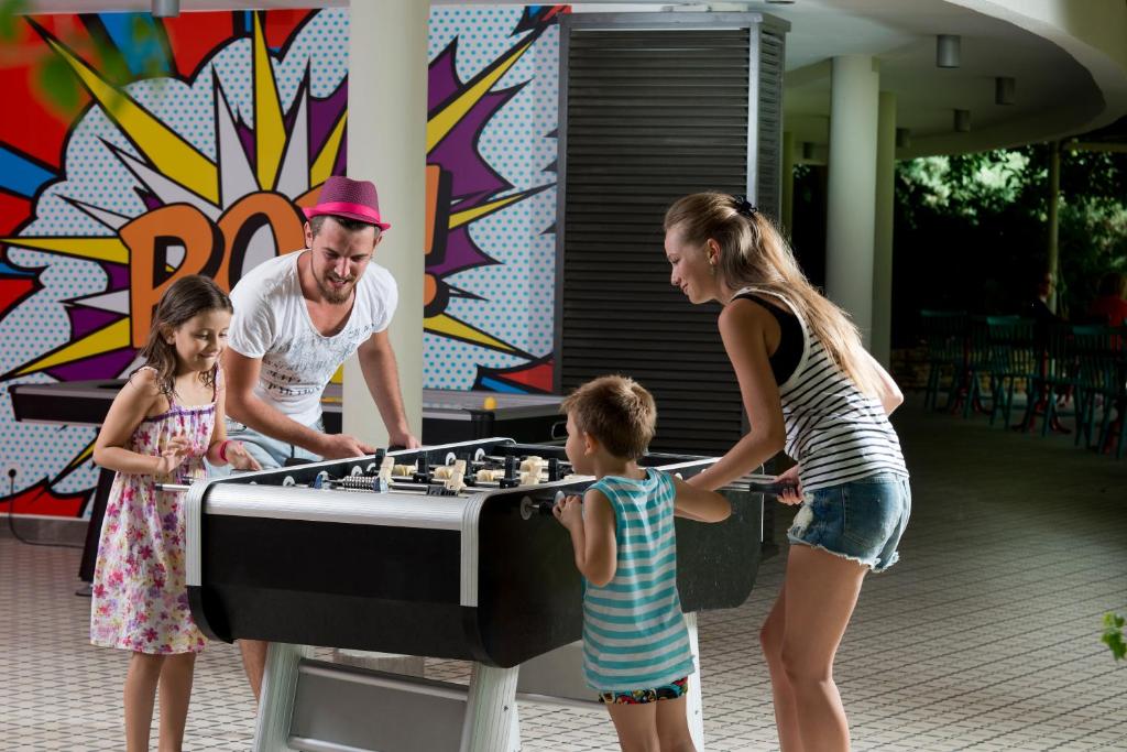 Bērni spēlē galda futbolu pie Lara Barut Collection.