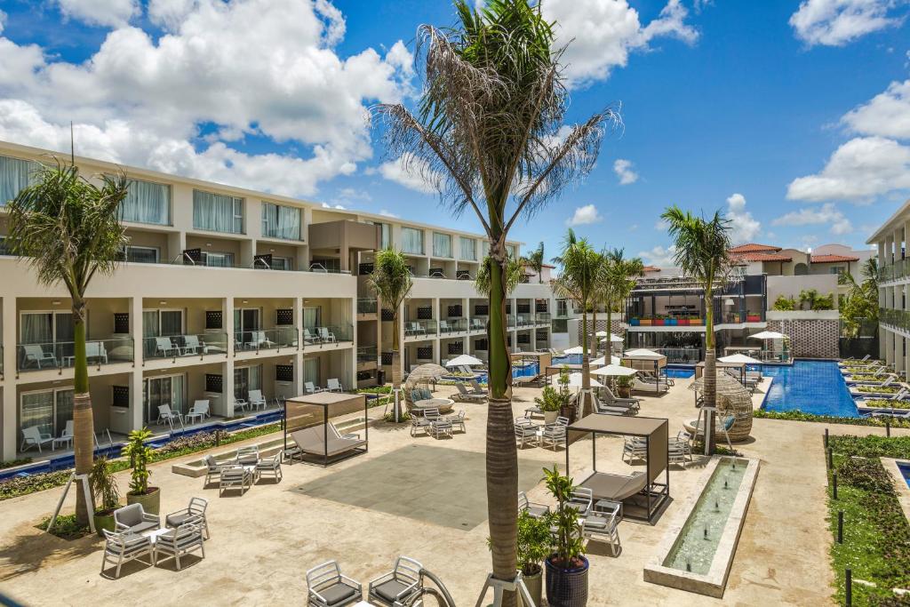 Mūsdienīgs kūrorts ar skatu uz baseinu un atpūtas zonām, ko ieskauj palmām un saulessargiem. Ideāla vieta relaksācijai un atpūtai.