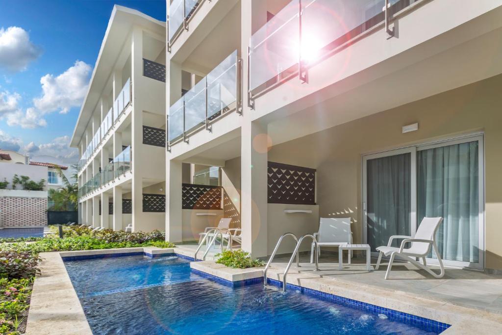 Mūsdienīga viesnīca ar terasi un privātu baseinu, kas ieskauta zaļumiem un ziediem, ideāla atpūtai saulainā laika apstākļos.