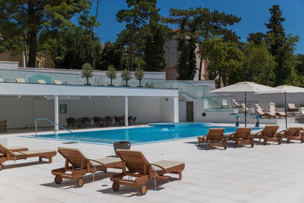 Mūsdienīgs baseins ar sauļošanās krēsliem un atpūtas zonu, ieskauts zaļumiem. Ideāla vieta relaksācijai un atpūtai pie ūdens.