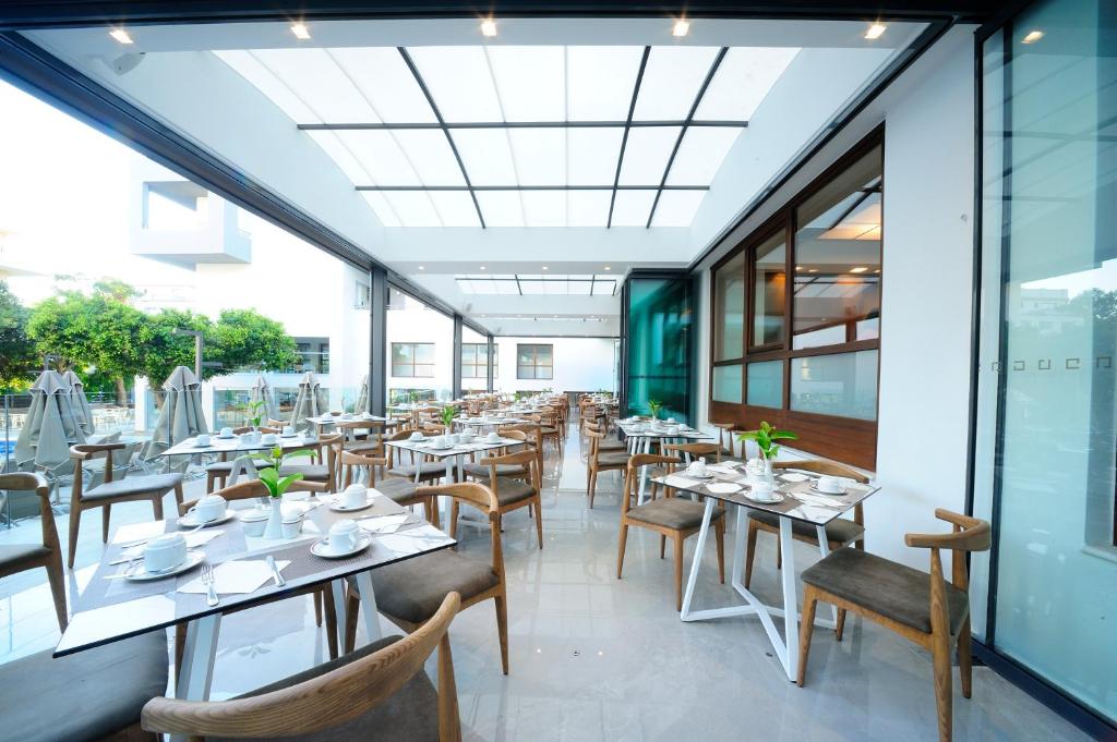 Pusdienu zona Atrium Ambiance Hotel ar modernu interjeru un dabīgu apgaismojumu.