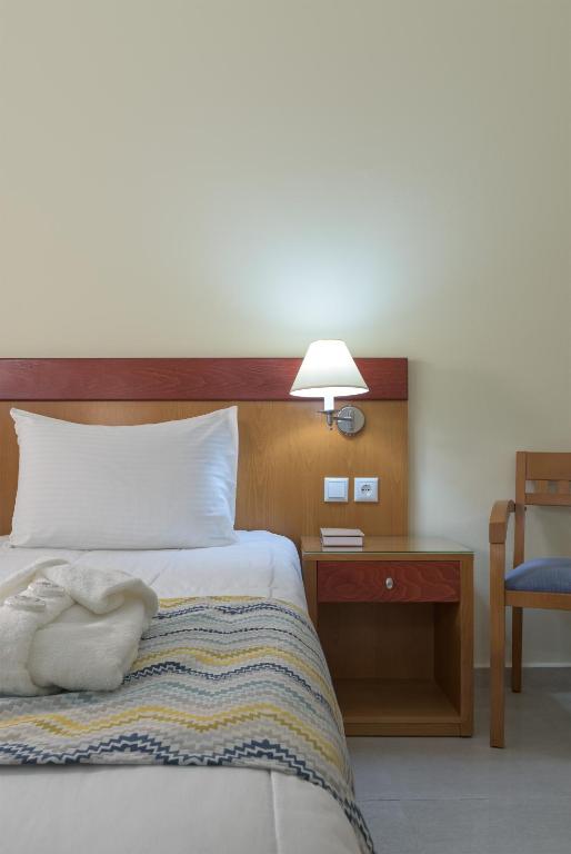 Mūsdienīgs guļamistabas interjers ar ērtu gultu, naktsgaldiņu un gaismas avotu, kas rada relaksējošu atmosfēru. Ideāla vide atpūtai un komfortam.