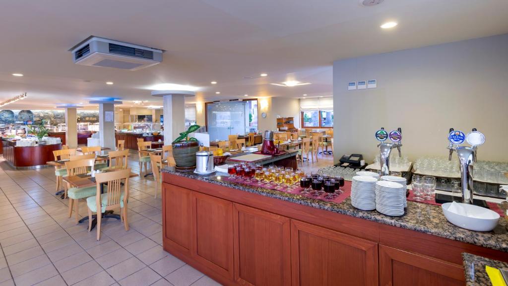 Restorāns viesnīcā Dessole Malia Beach ar bufetes galdu un sēdvietām.