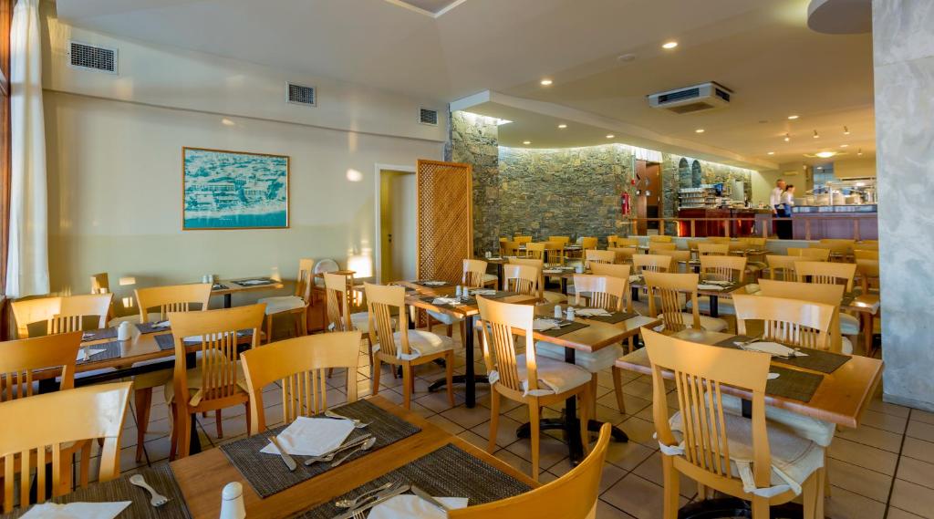 Restorāns viesnīcā Dessole Malia Beach ar koka galdiem un krēsliem