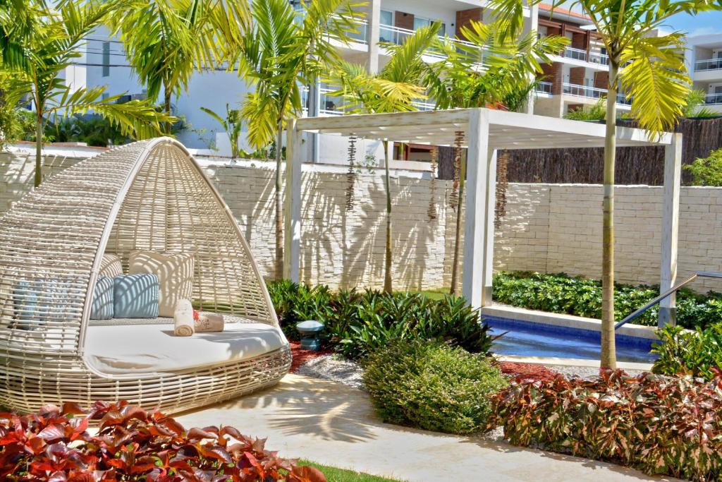 Dabīgā stila atpūtas zona ar pītām mēbelēm un zaļiem augiem, kas nodrošina mierīgu atmosfēru. Ideāla vieta relaksācijai un dārza izbaudīšanai.