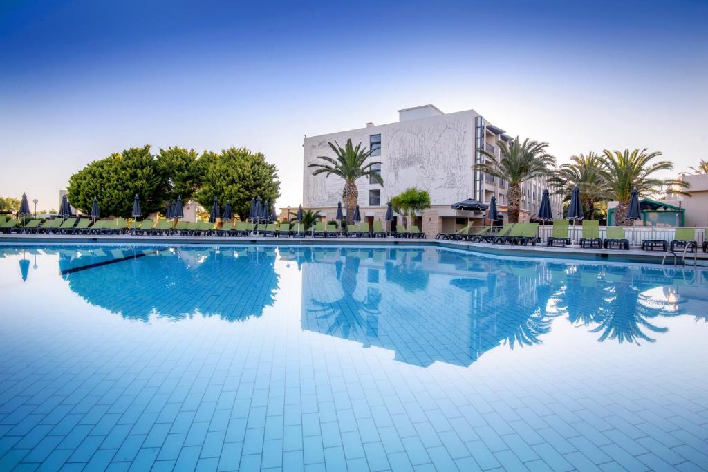 Sol Marina Beach Crete baseins ar palmām un saulessargiem piekrastē