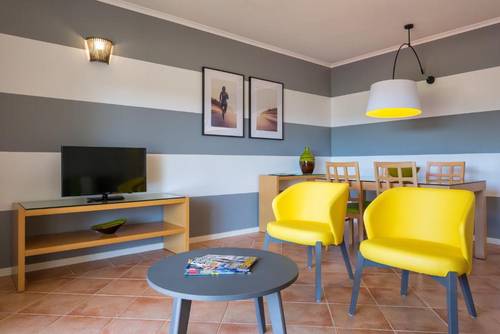 Plaša atpūtas zona ar TV un dzelteniem atpūtas krēsliem AP Victoria Sport & Beach Hotel.