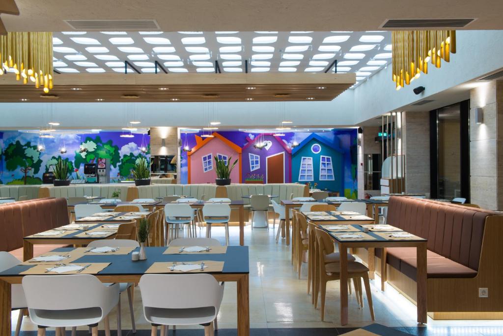 Mūsdienīgs restorāns Fodele Beach & Water Park Resort ar krāsainu sienas gleznojumu.