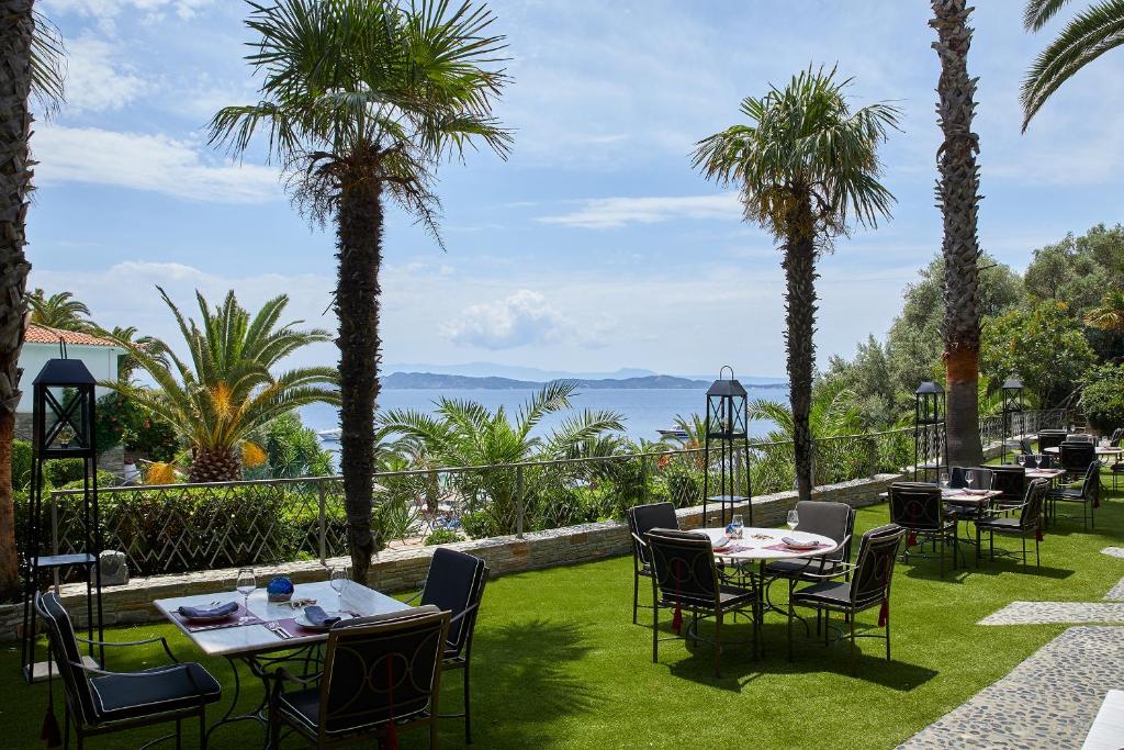 Skaista terase ar skatu uz jūru, kur novietoti galdi un krēsli, apkārt augošas palmas un zāle. Ideāla vieta relaksācijai un maltītēm brīvā dabā.