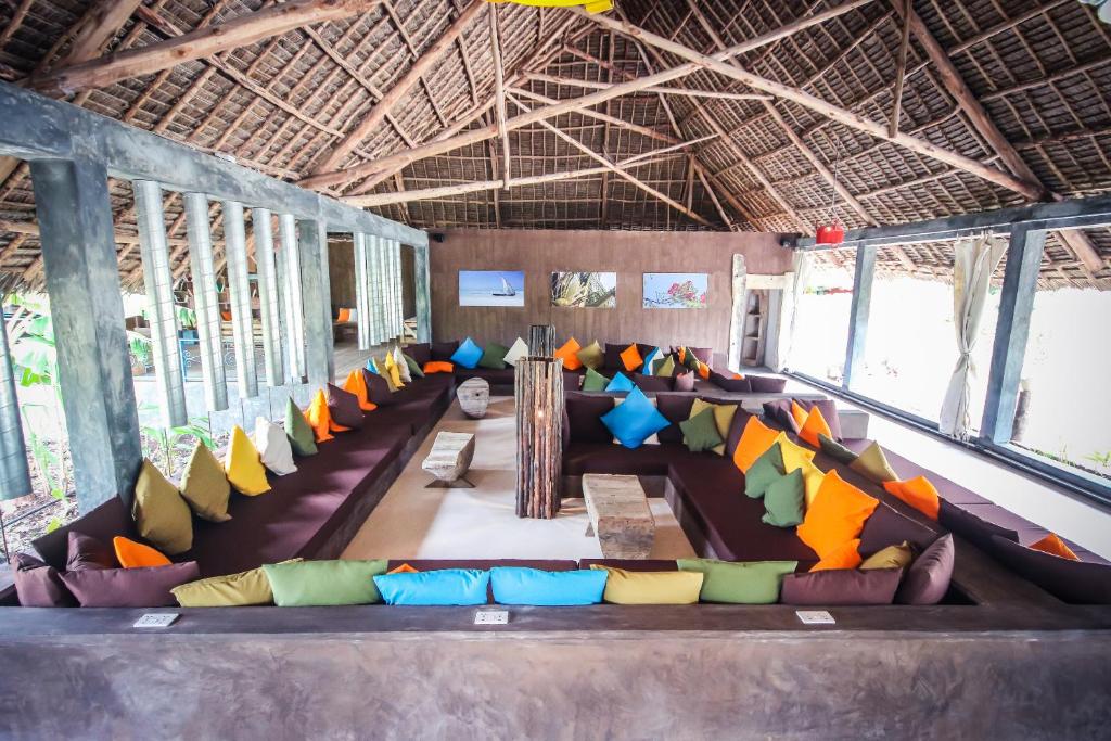 Fun Beach Zanzibar viesnīcas atpūtas zona ar spilgtām spilveniem.